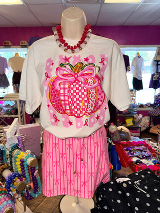 Ivory tee with a pink pumpkin graphic supporting breast cancer awareness, displayed on a mannequin.