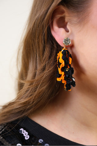 Orange and black sequin fringe earrings with a rhinestone stud.