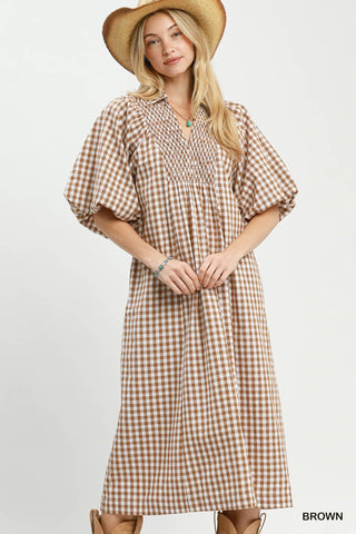 A brown plaid midi dress with puff sleeves and a V-neckline, worn by a model.