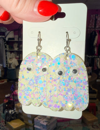 Ghost-shaped earrings with multicolor glitter and googly eyes on a clear acrylic base.