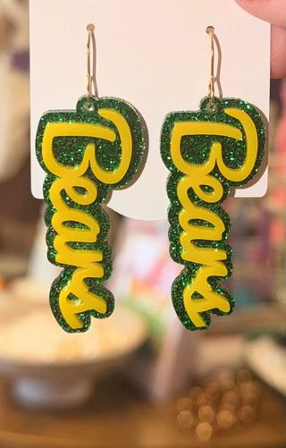 A pair of earrings with a glittery green and yellow Bears motif and hook fastening.