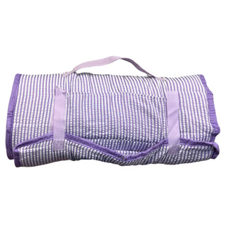 A rolled-up purple and white striped nap mat with attached carrying handle and secure straps.