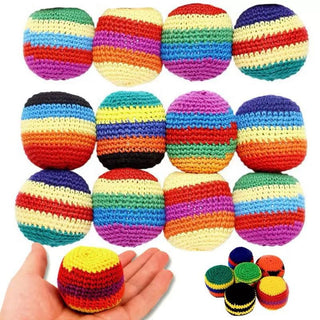 Colorful striped crochet balls with a hand holding one ball for scale.