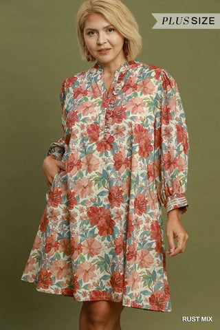 A woman wearing a red floral print mini dress with a v-neckline and 3/4 length puff sleeves with smocked cuffs.