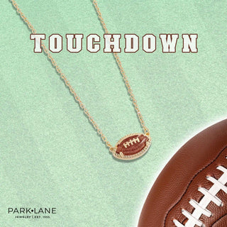 Gold necklace with a football-themed pendant, displayed against a light green background.